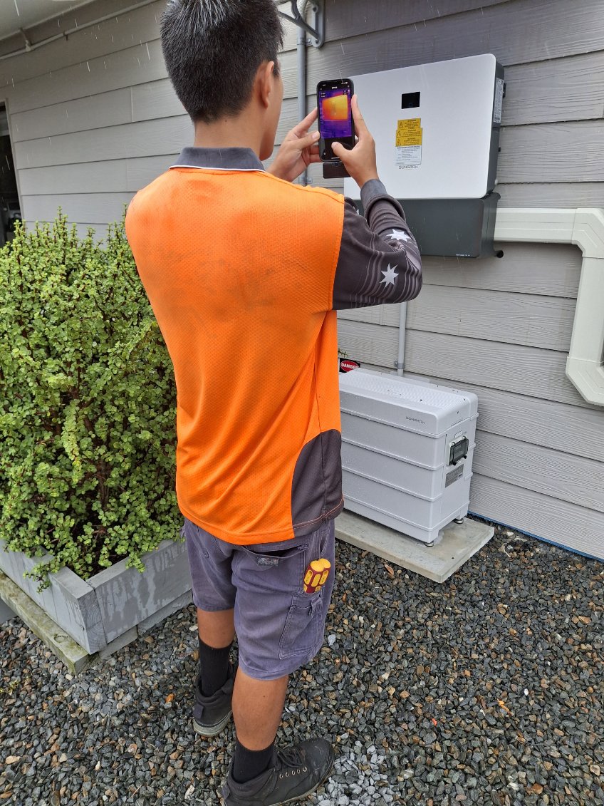 technician performing a thermal scan on an inverter.