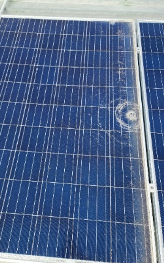 A solar panel tat has been hit by a large hailstorm causing a circular cracking pattern. 